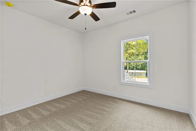 an empty room with chandelier fan