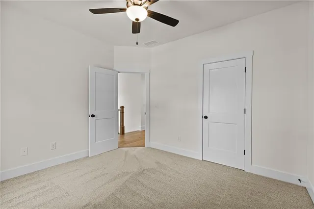 an empty room with a window and a ceiling fan