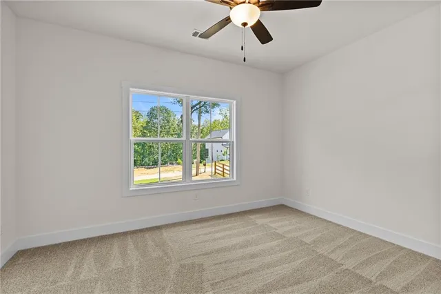 a view of an empty room and chandelier fan
