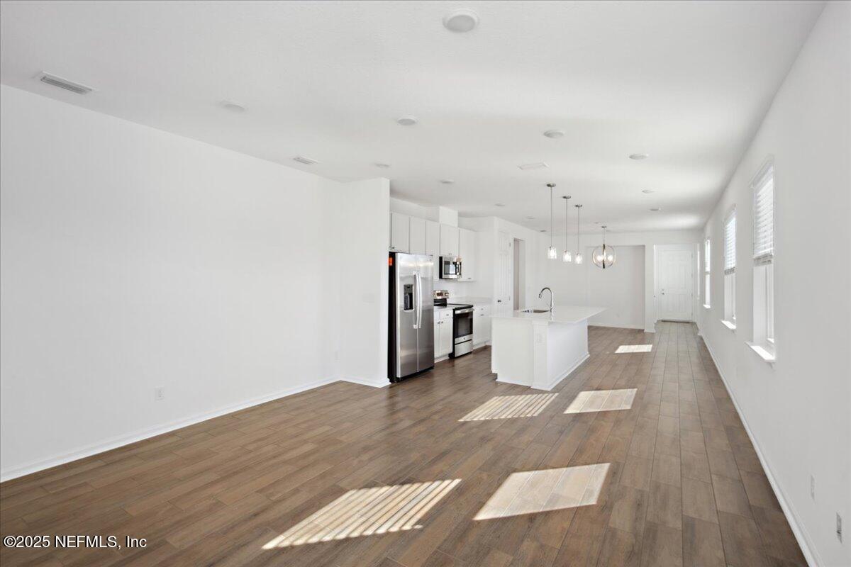7212 Red Timber Road Jacksonville, FL 32244 - Photo 11 of 31 a view of a big room with wooden floor and windows