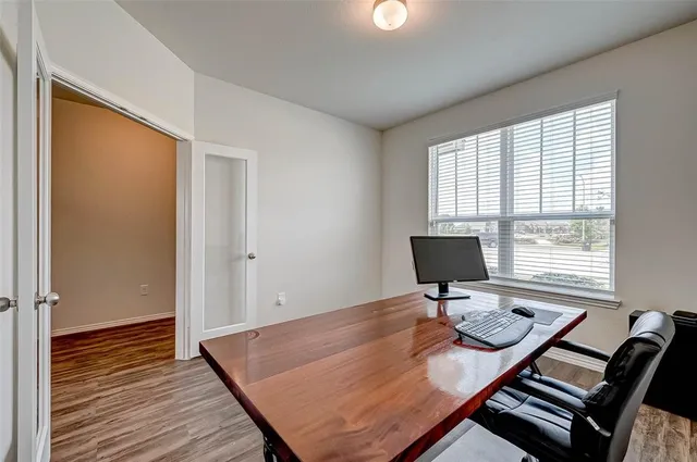a view of a workspace with furniture and a window