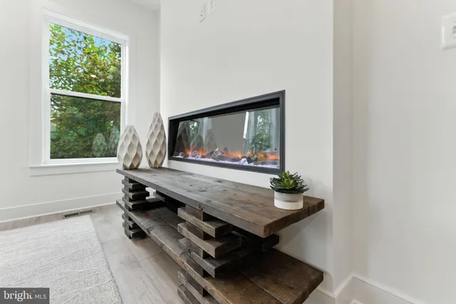 a living room with furniture kitchen view and a chandelier