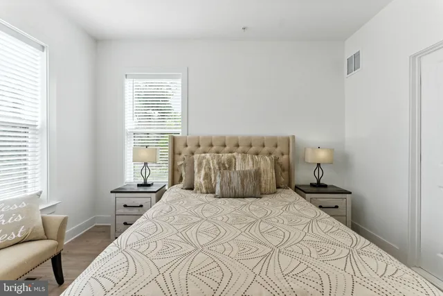 a bedroom with a large bed and a flat tv screen on dresser