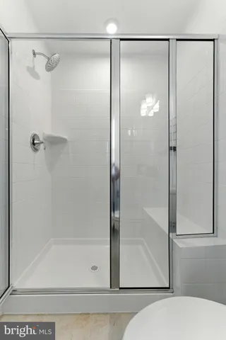 a view of road with card parked on side and retail shops