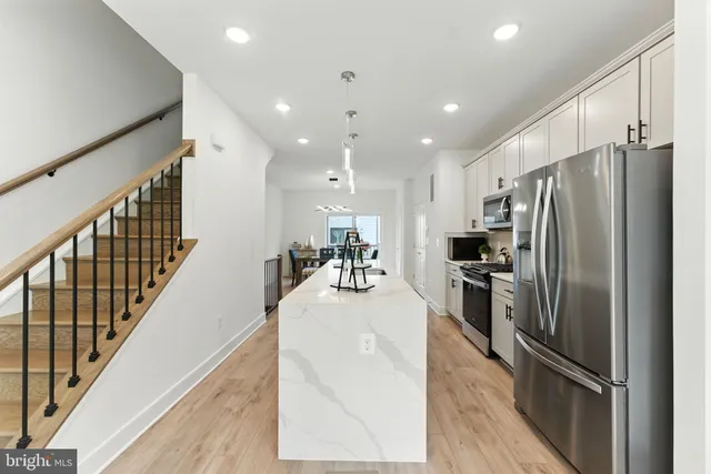 a kitchen with stainless steel appliances granite countertop a refrigerator and a stove top oven