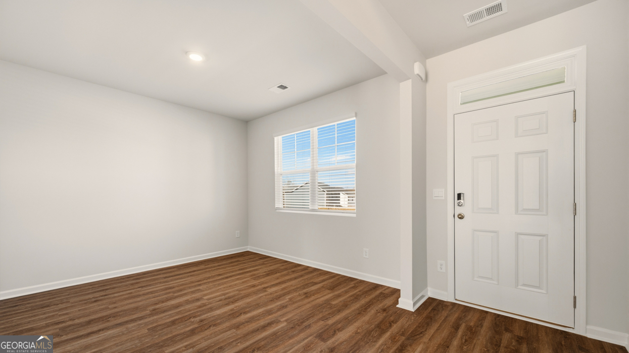 8578 Seabiscuit Road Lithonia, GA 30058 - Photo 3 of 30 a view of an empty room with wooden floor and a window