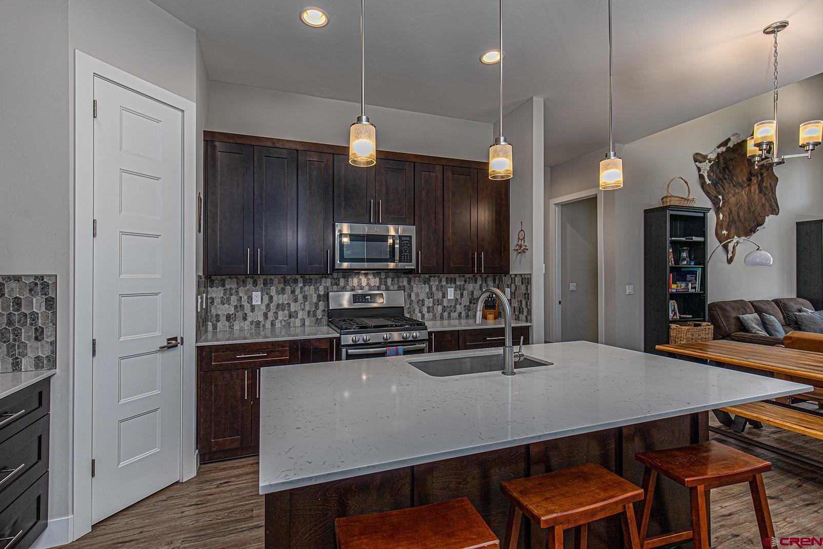 107 Tacoma Drive Durango, CO 81301 - Photo 6 of 29 a kitchen with stainless steel appliances a dining table chairs refrigerator and microwave