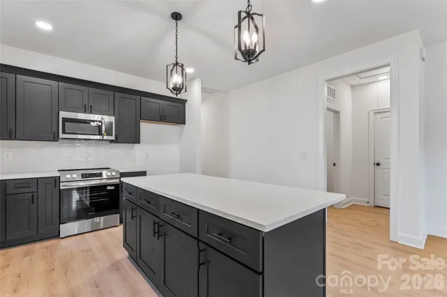 a kitchen with kitchen island a sink stainless steel appliances and cabinets