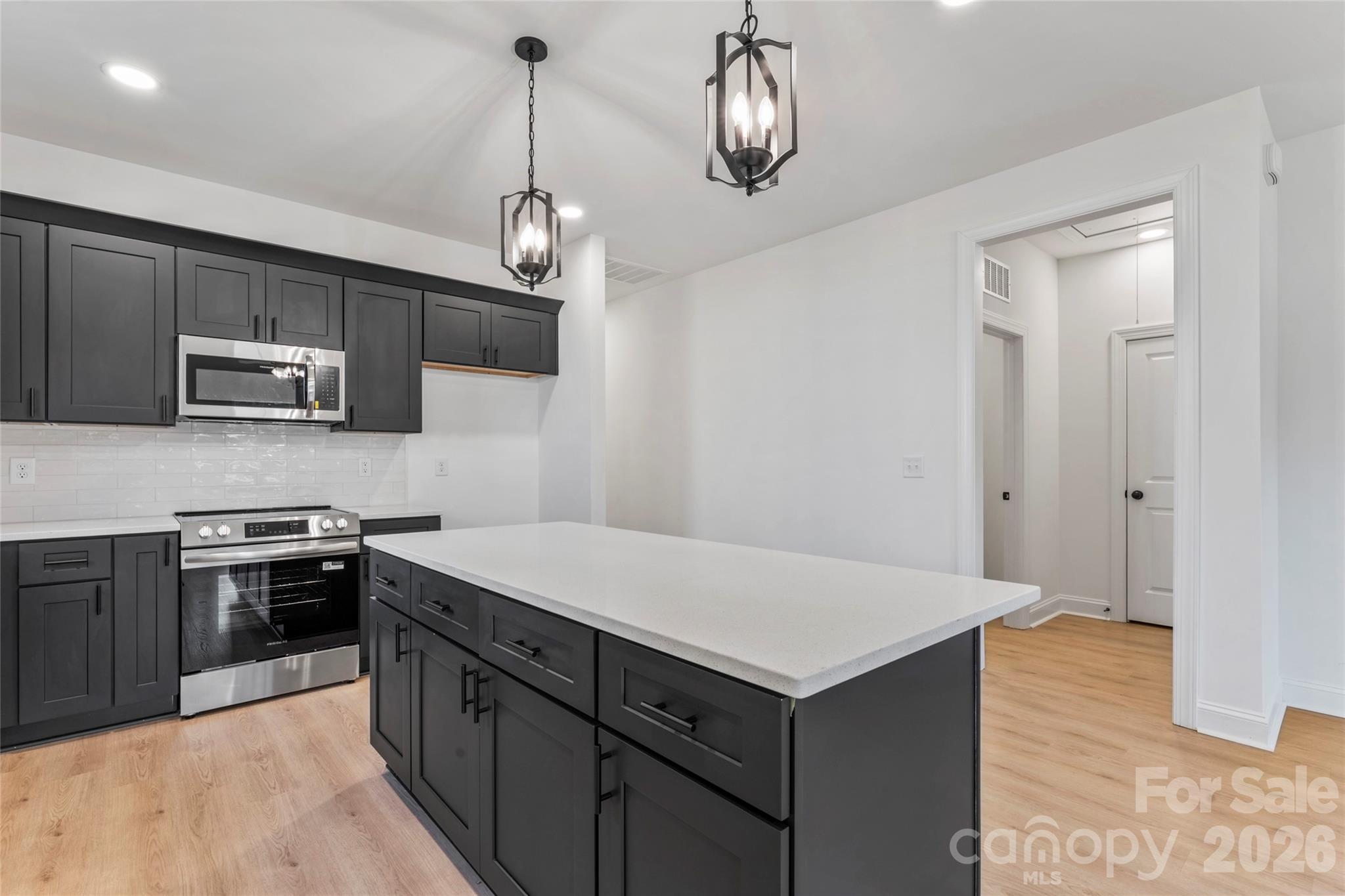 755 Mockingbird Road, Unit 3 Albemarle, NC 28001 - Photo 11 of 25 a kitchen with kitchen island a sink stainless steel appliances and cabinets
