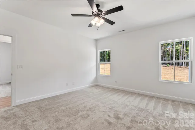 an empty room with a window and a fan