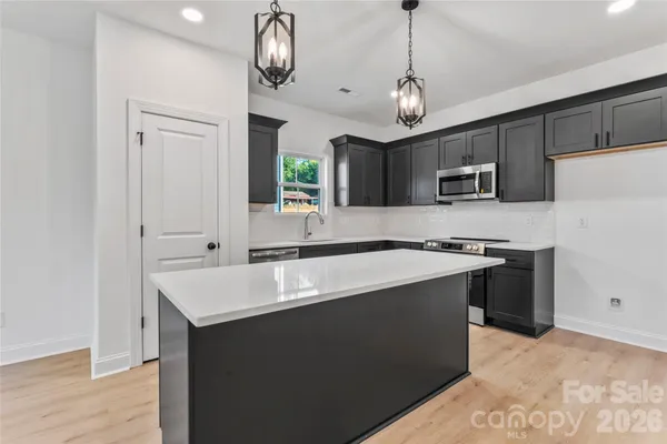 a kitchen with kitchen island a sink stainless steel appliances and window