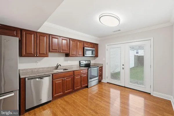 a kitchen with stainless steel appliances granite countertop a stove a sink dishwasher and a refrigerator