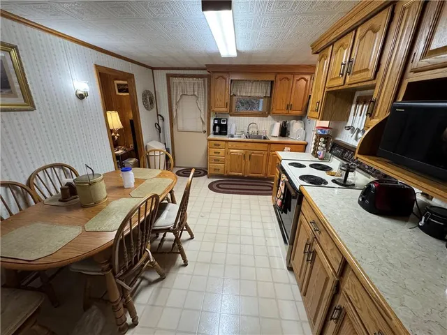 a kitchen with a table chairs a stove and a refrigerator