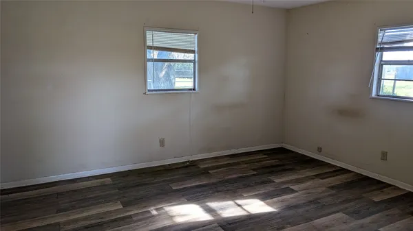 a view of a small space with wooden floor and a window