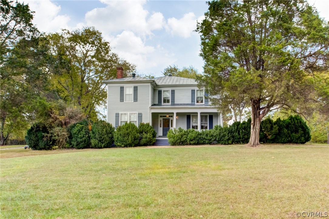 a front view of house with yard and trees around