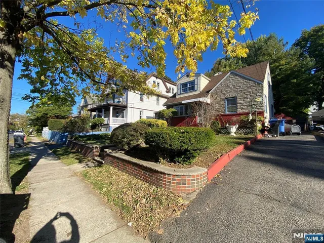 a front view of a house with a yard and potted plants