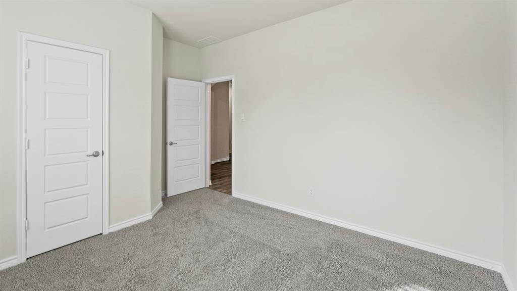 447 Epiphany Lane Lavon, TX 75166 - Photo 21 of 31 Neutral-toned interior with light gray walls and plush gray carpeting