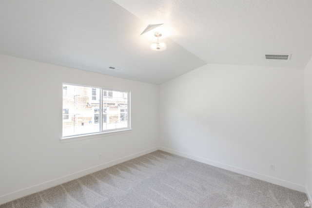 4769 Olive Avenue, Unit 411 Mapleton, UT 84664 - Photo 13 of 19 Empty room with vaulted ceiling and carpet flooring
