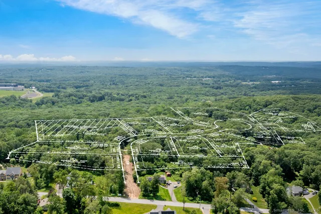 an aerial view of residential houses with outdoor space and trees