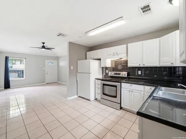 a kitchen with a refrigerator sink and cabinets