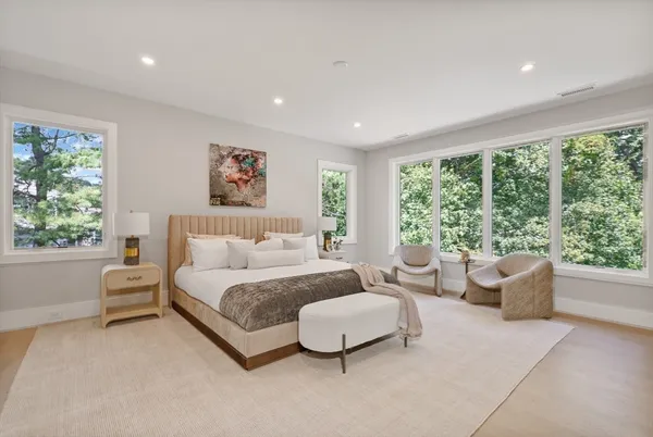 a spacious bedroom with a bed and large windows