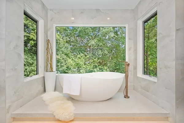 a white tub sitting in front of a window