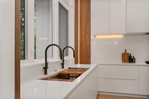 a kitchen with a sink and a stove next to a window