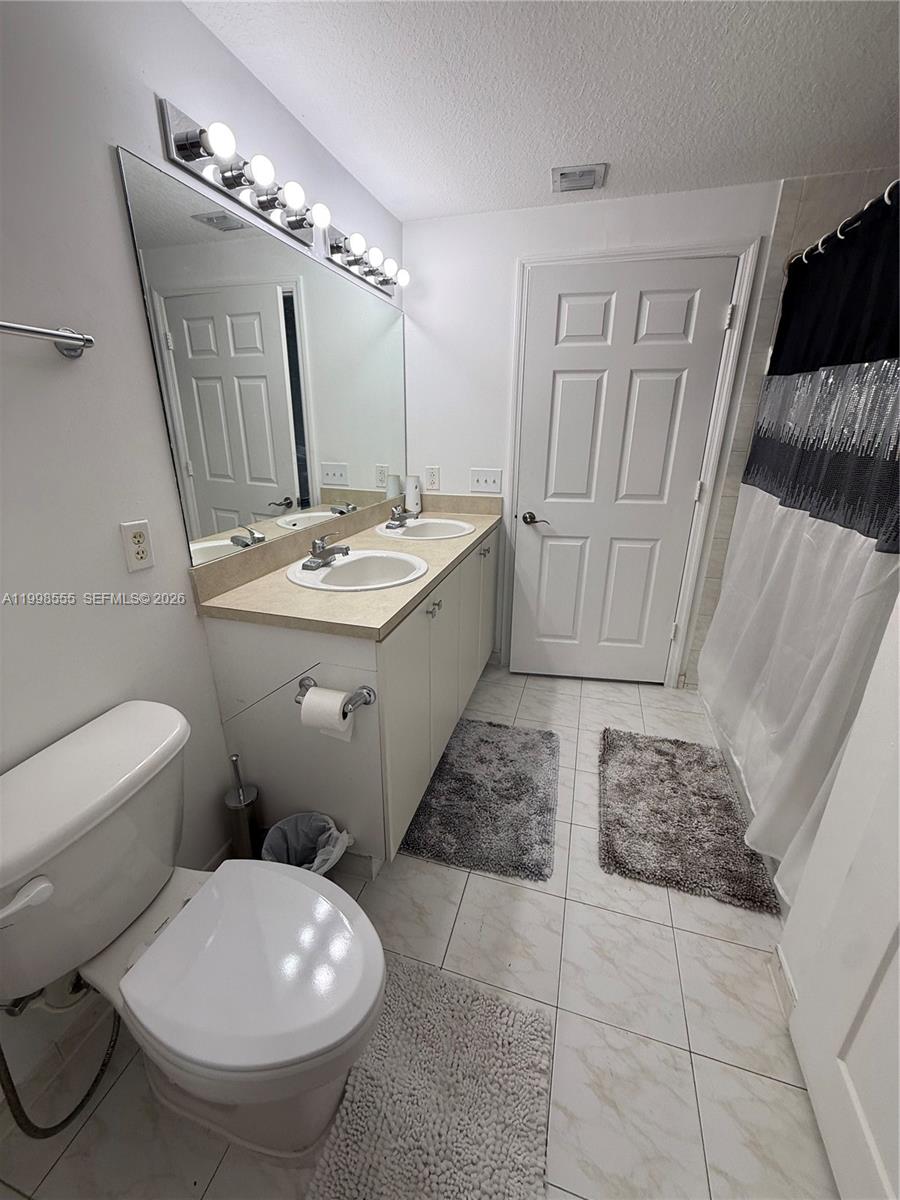 119 Southwest 6th Avenue, Unit 405 Miami, FL 33130 - Photo 11 of 23 a bathroom with a toilet sink and mirror