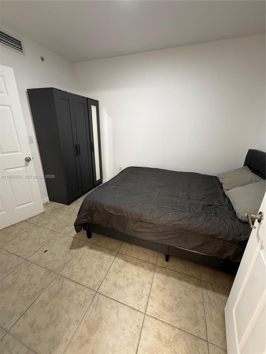 119 Southwest 6th Avenue, Unit 405 Miami, FL 33130 - Photo 13 of 23 a bedroom with a bed and a mirror