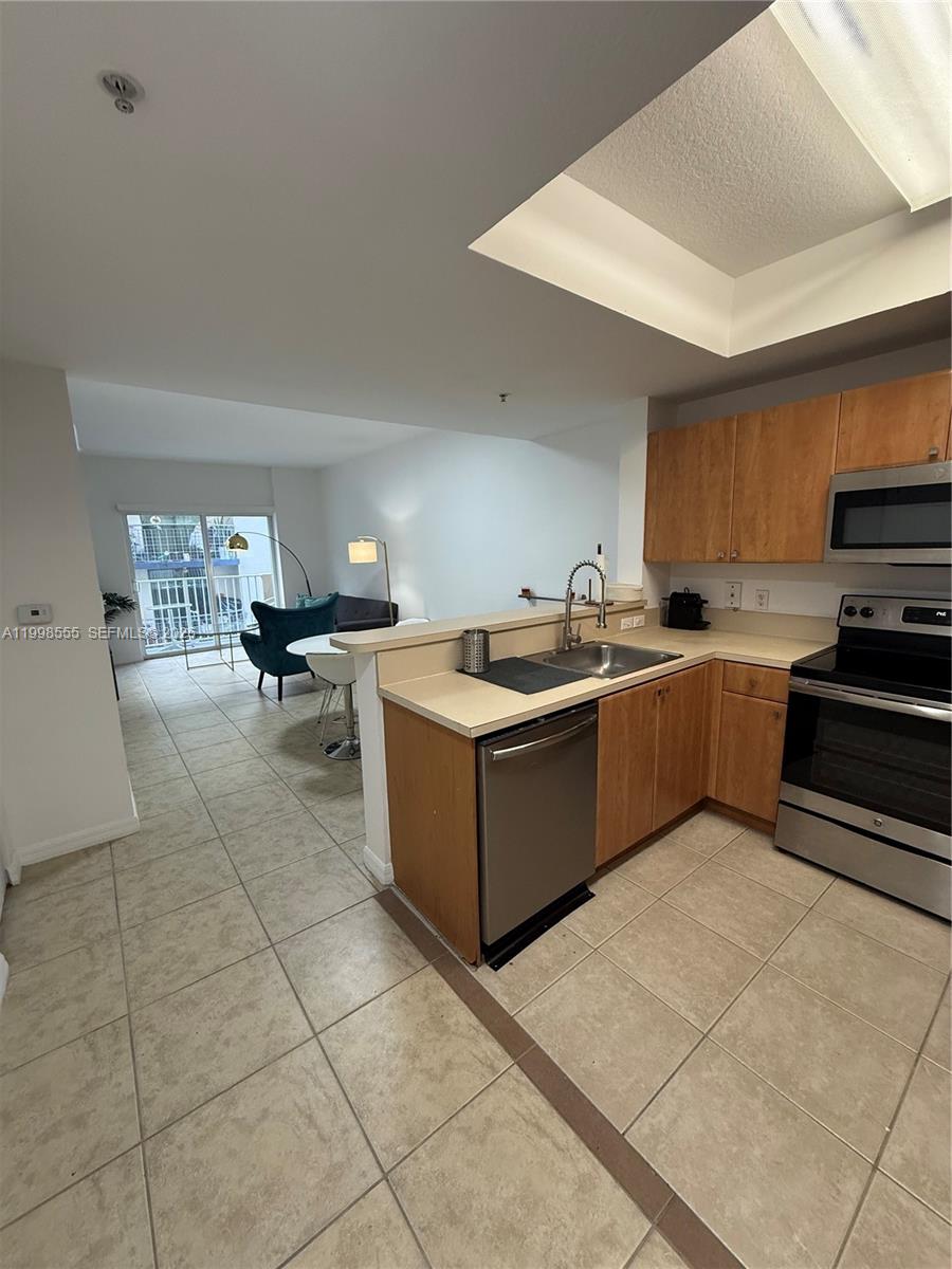 119 Southwest 6th Avenue, Unit 405 Miami, FL 33130 - Photo 2 of 23 a kitchen with stainless steel appliances granite countertop a sink and cabinets