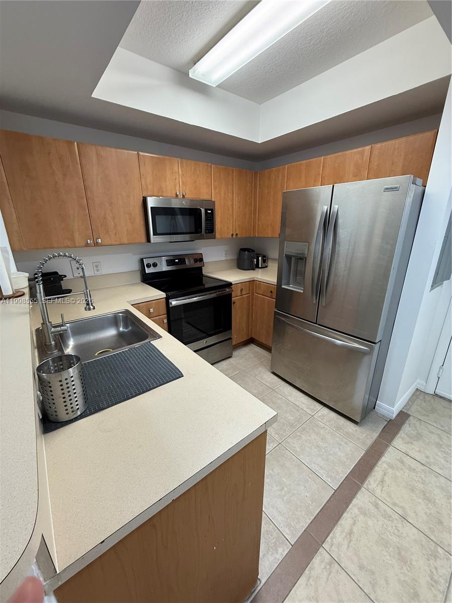119 Southwest 6th Avenue, Unit 405 Miami, FL 33130 - Photo 3 of 23 a kitchen with stainless steel appliances a refrigerator sink and stove