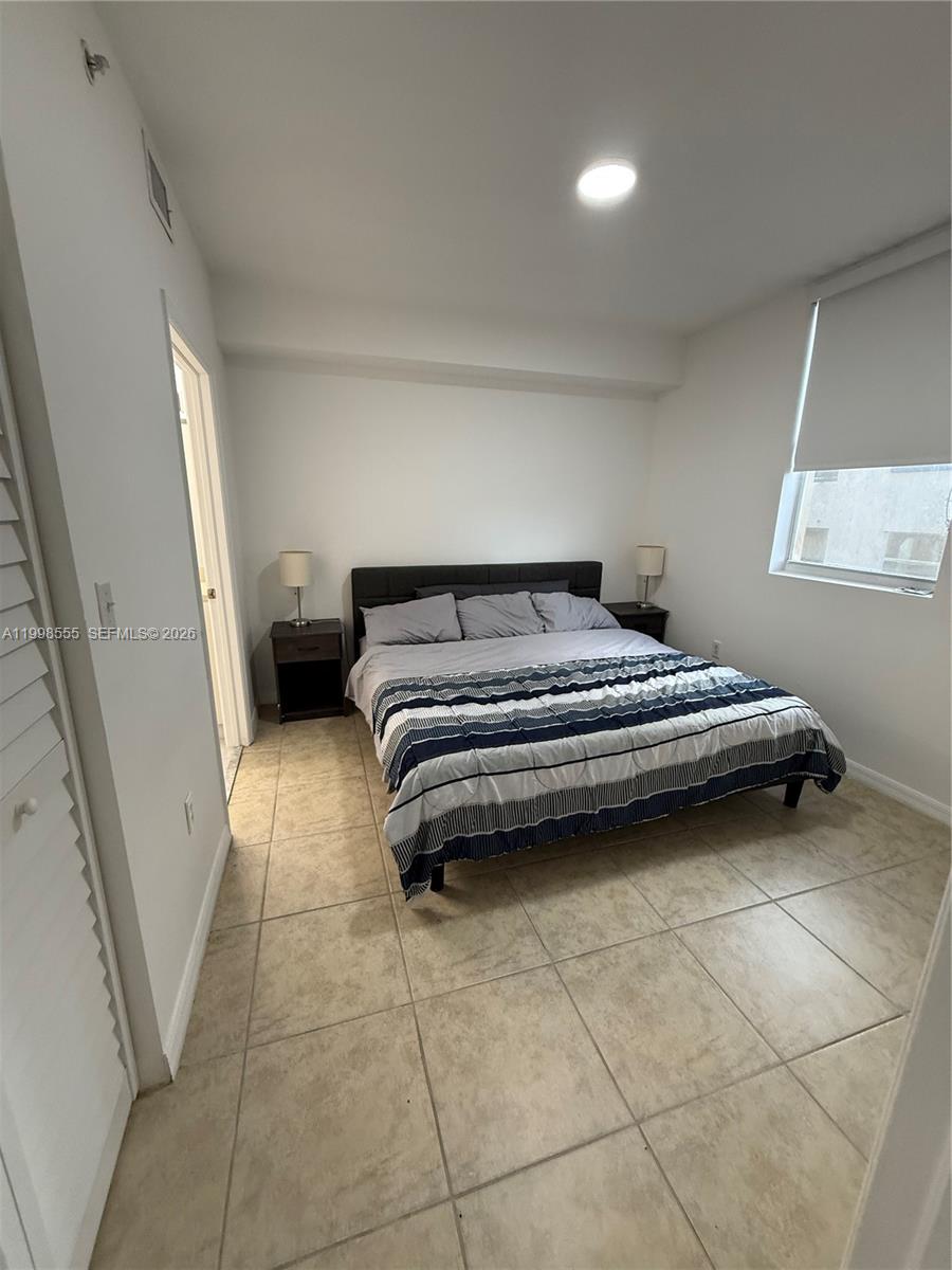 119 Southwest 6th Avenue, Unit 405 Miami, FL 33130 - Photo 8 of 23 a bedroom with a bed and a cabinets