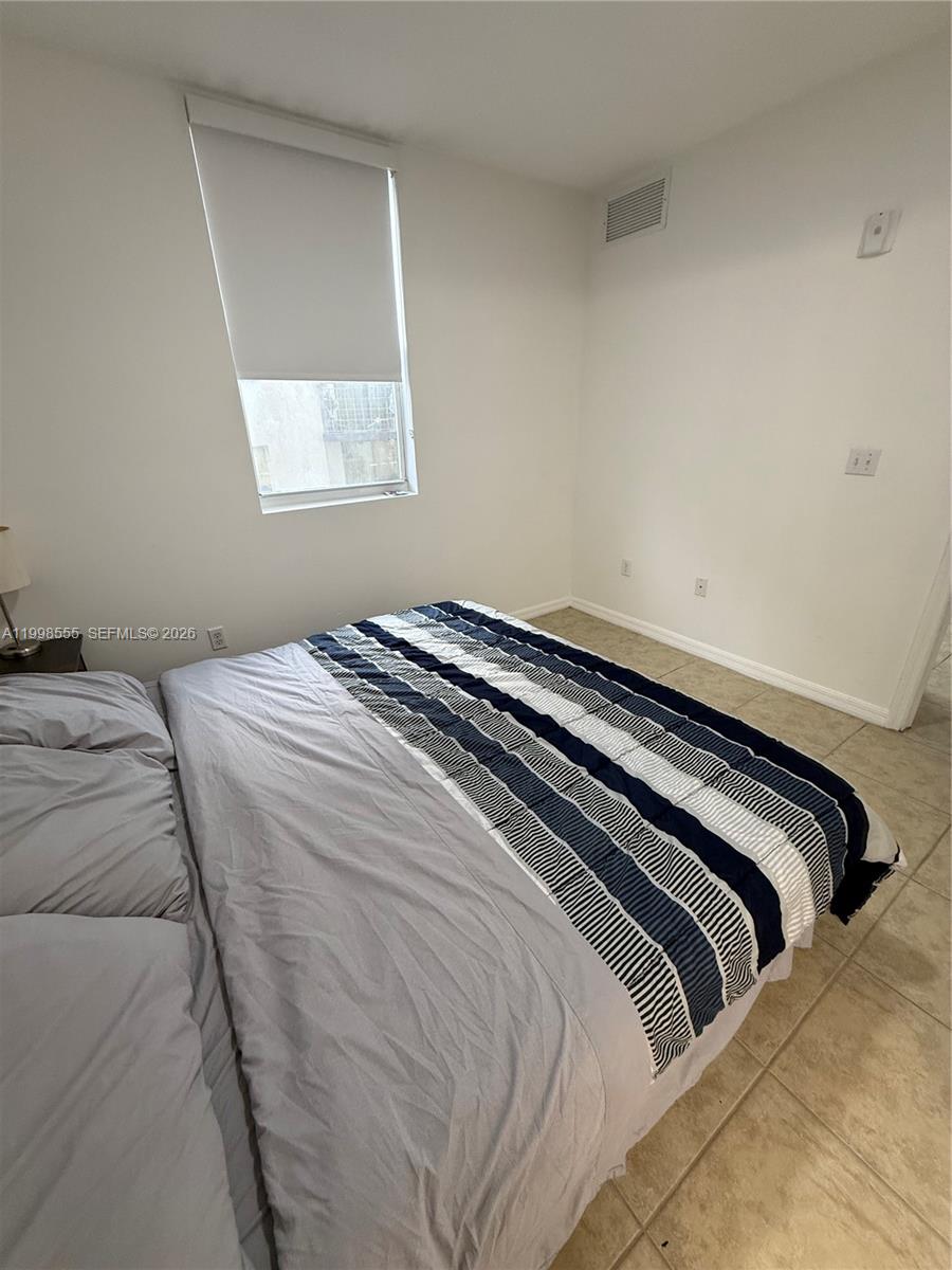 119 Southwest 6th Avenue, Unit 405 Miami, FL 33130 - Photo 9 of 23 a bedroom with a bed and a window