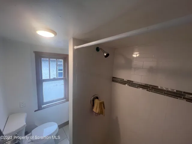 a bathroom with a shower a toilet and sink