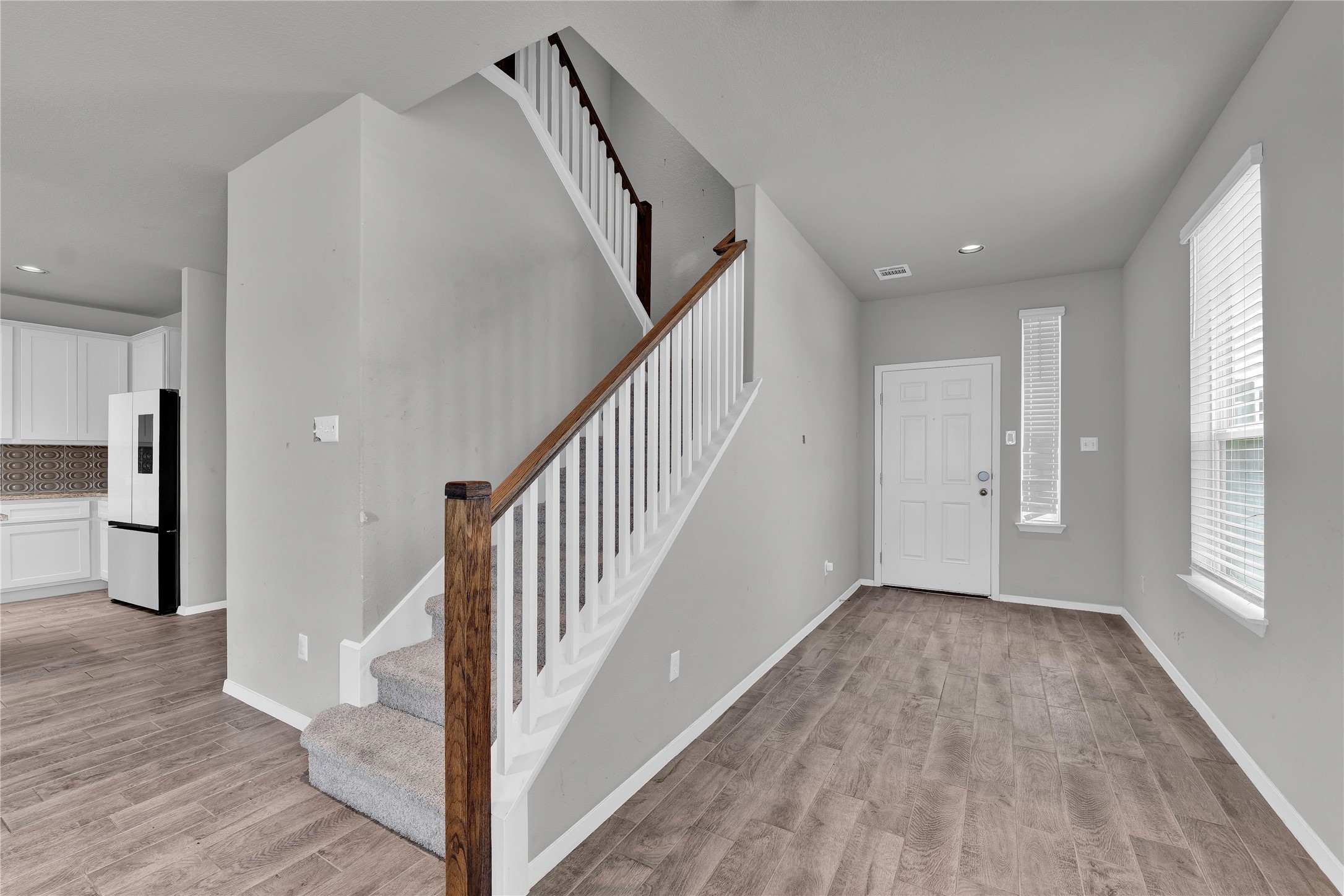 101 Crescent Street Georgetown, TX 78626 - Photo 3 of 39 A welcoming entryway boasts rich wood flooring and a modern staircase with white risers.