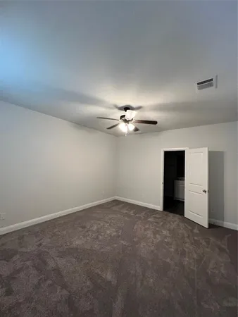 an empty room with a ceiling fan and a window