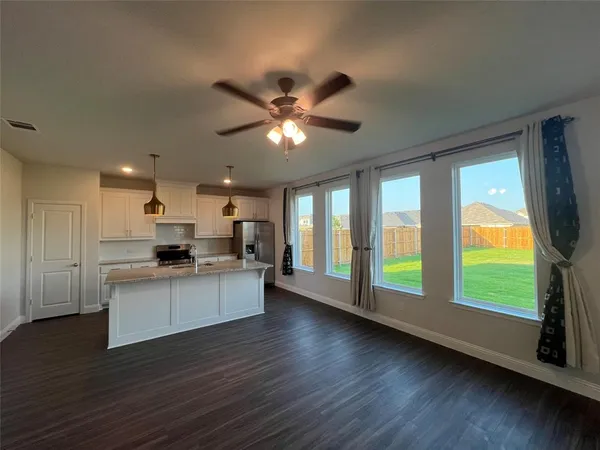 a kitchen with stainless steel appliances kitchen island wooden floors and white cabinets