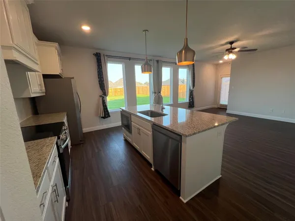 a kitchen with sink a refrigerator and wooden floor