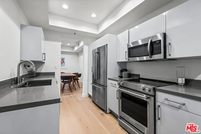 a kitchen with stainless steel appliances granite countertop a stove a sink and a microwave