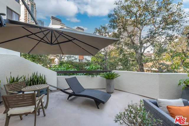 a view of patio with table and chairs under an umbrella
