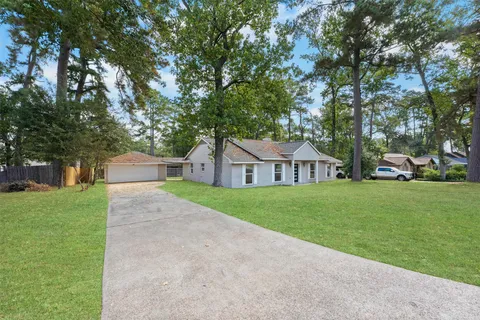 a front view of a house with a yard and trees
