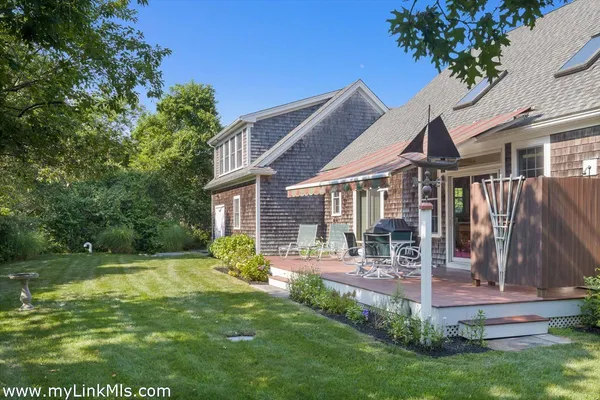 a view of a house with a yard and sitting area