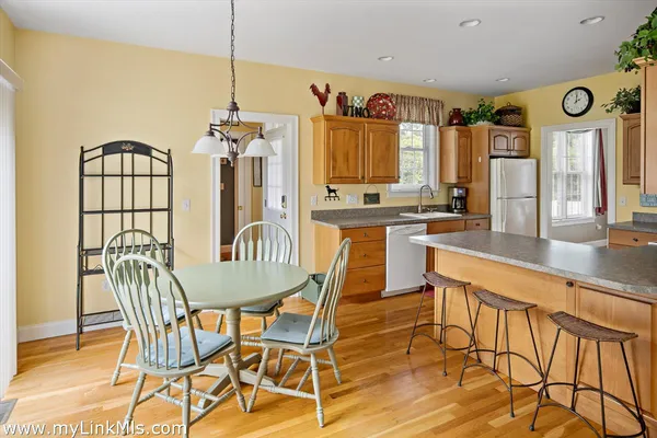 a kitchen with stainless steel appliances kitchen island granite countertop a table and chairs in it