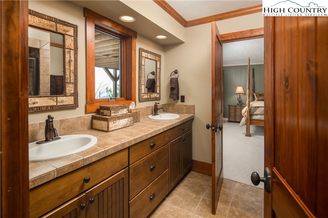 260 Beacon Hill Blowing Rock, NC 28605 - Photo 31 of 47 a en suite bathroom with a granite countertop sink mirror and shower
