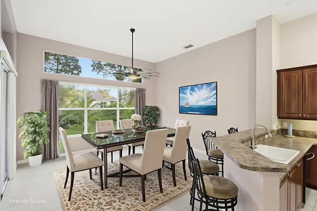 a bathroom with a granite countertop sink a large mirror and a large window