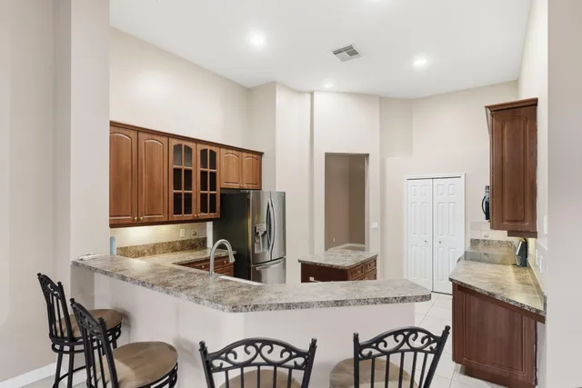 a kitchen with kitchen island granite countertop a stove top oven a sink a counter space and cabinets