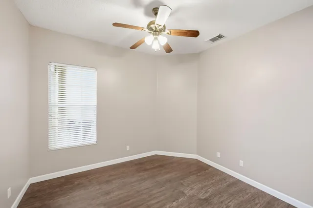 wooden floor in an empty room with a window