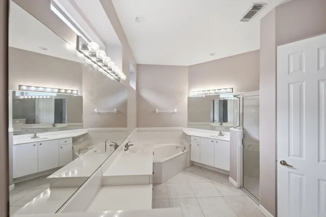 a spacious bathroom with a double vanity sink and a mirror