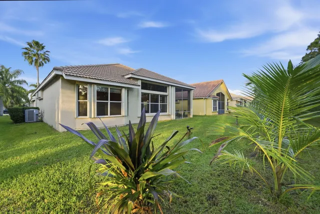 a front view of a house with a yard and potted plants