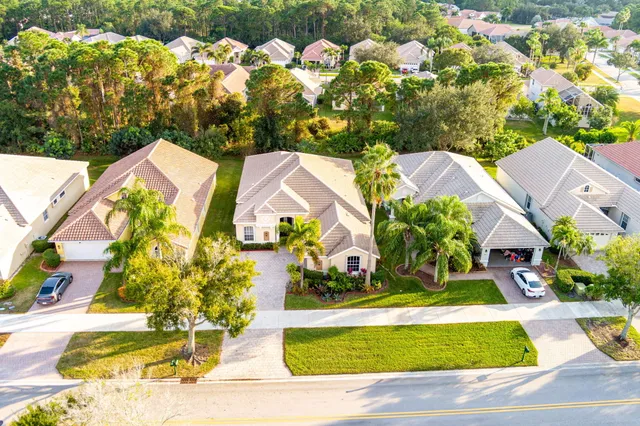 a aerial view of a house with swimming pool and next to trees